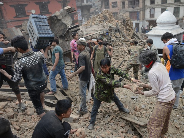 Moradores e equipes de resgate entre escombros no Nepal