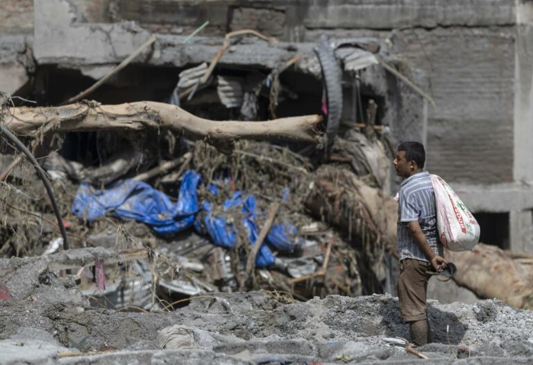 Homem observa a destruição deixada pela lama no Nepal
